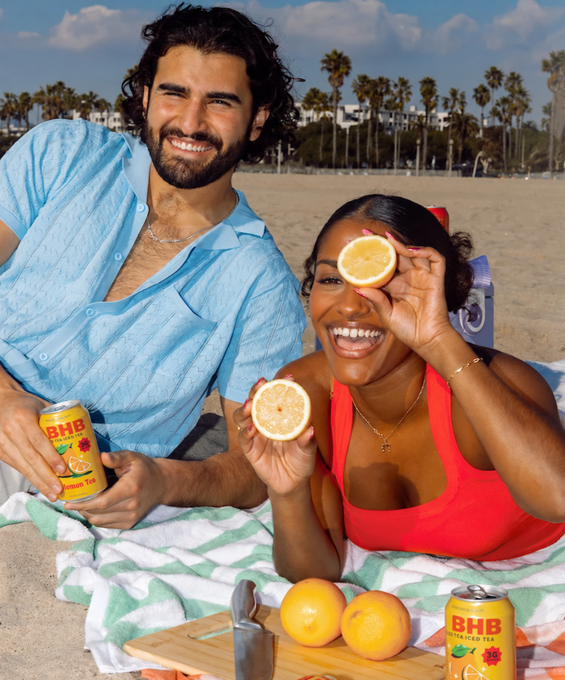 Friends sharing BHB Lemon Tea and fresh lemons at a beach picnic